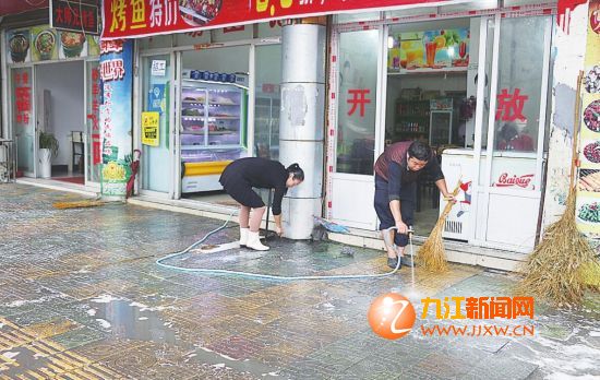 烧烤摊业主在店门口清洗人行道。